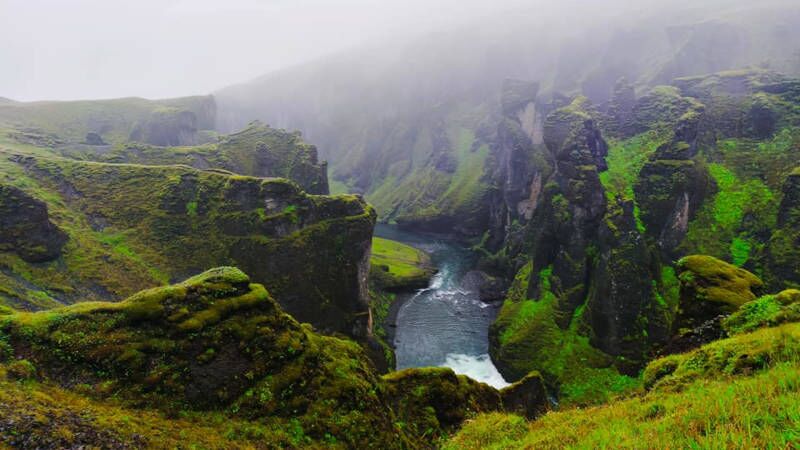 Fjaðrárgljúfur River Canyon on a cloudy day, green gorge with a river