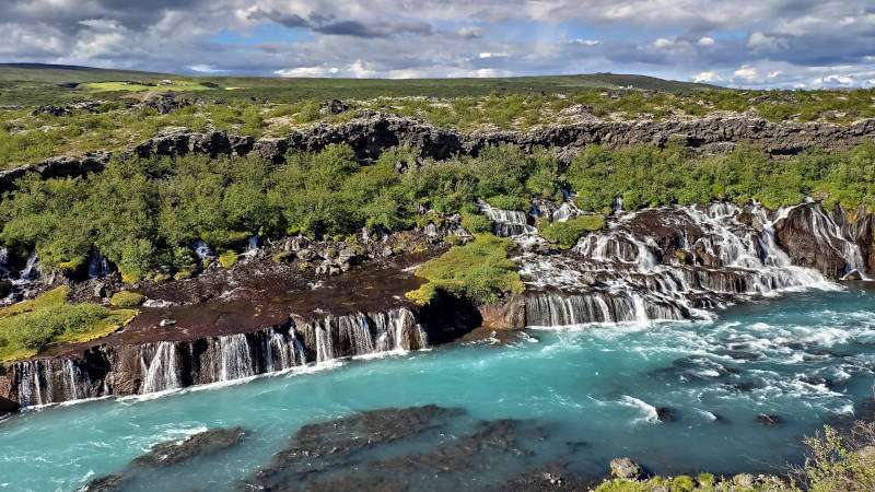 Hraunfossar Waterfall Iceland, panoramic view over the falls coming out of the lava field