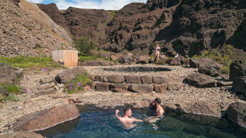 Húsafell Canyon Baths, people chilling in geothermal pools on a sunny day
