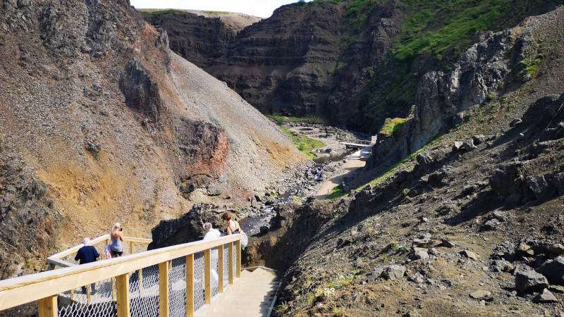 Canyon Baths in Husafell, staircase leading to the baths located in the canyon on a sunny days with people walking down