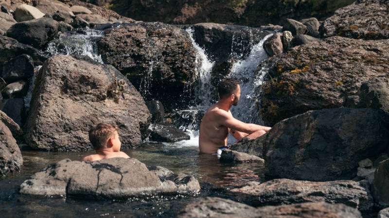 Canyon Baths in Husafell, young men cooling down under a natural waterfall