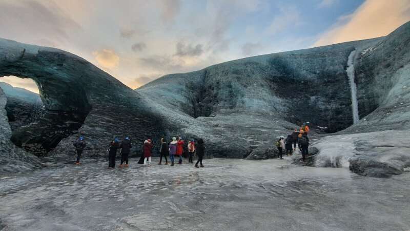 Vatnajokull Glacier and people walking on the ice at sunset