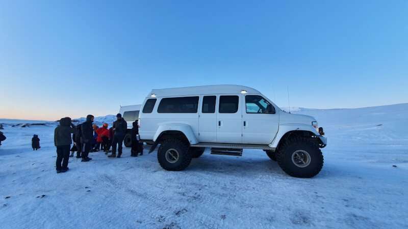 Ice Cave 4WD, car on snowy plains with people preparing for the tour