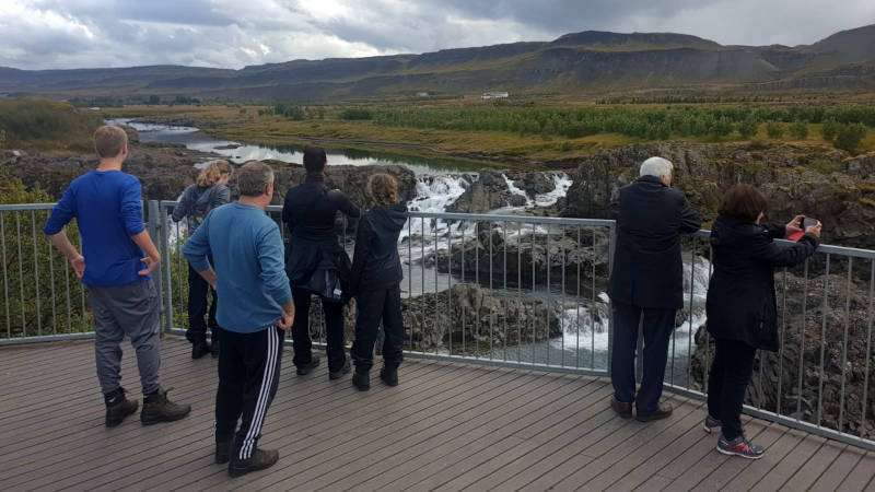 People admiring the view over the Glanni Waterfall