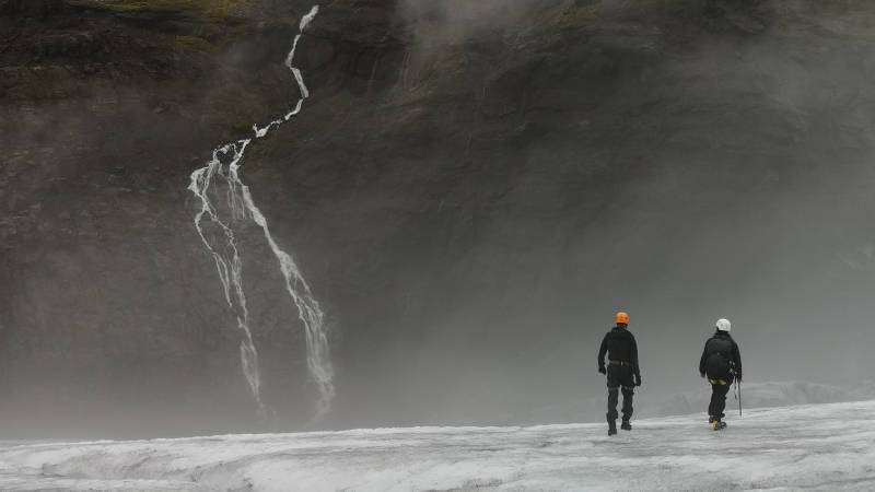 People walking on a glacier in the mist
