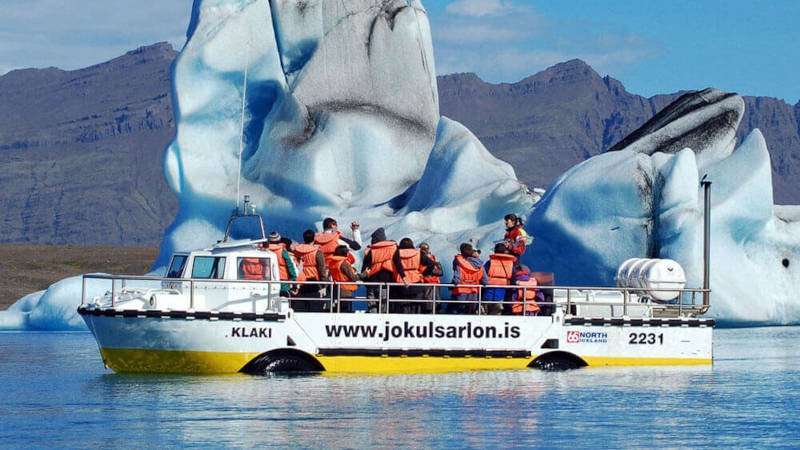 Amphibious Boat in the glacier lagoon with blue icebergs
