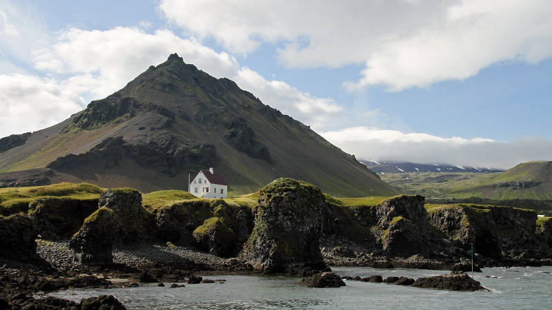 Arnarstapi cliffs with the white house and a mountain