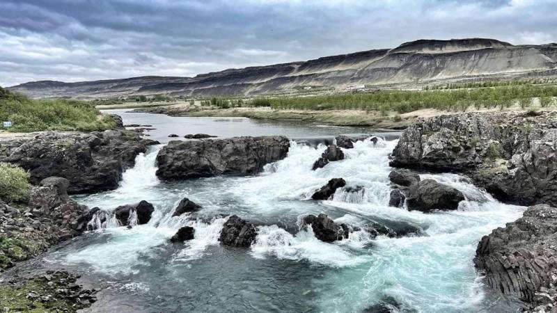 Glanni Waterfall on a cloudy day with mountains