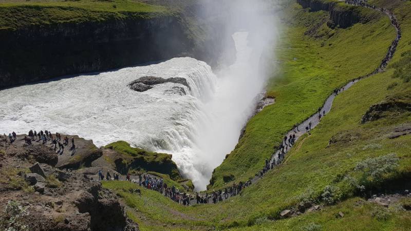 Gullfoss with emerald green grass fields