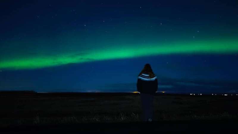 Person in icelandic woollen sweater with Aurora