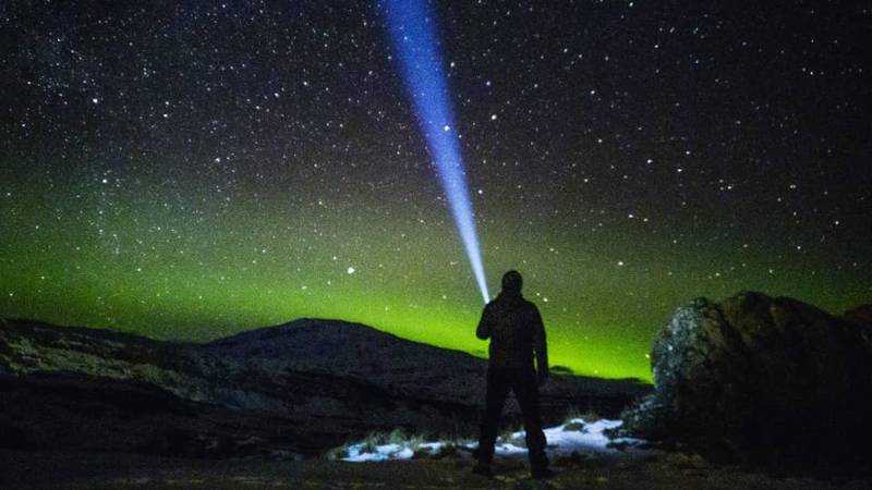 Aurora Nicetravel Tour man with a torch on a starry night