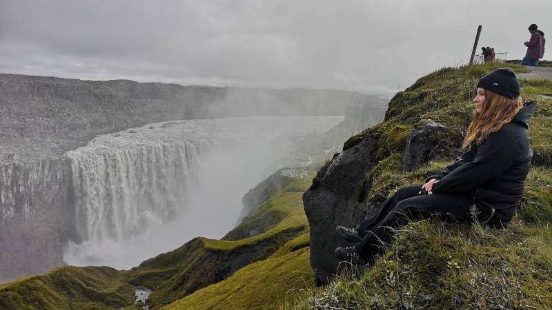 Dettifoss, a lady looking at the view on a cloudy dark day