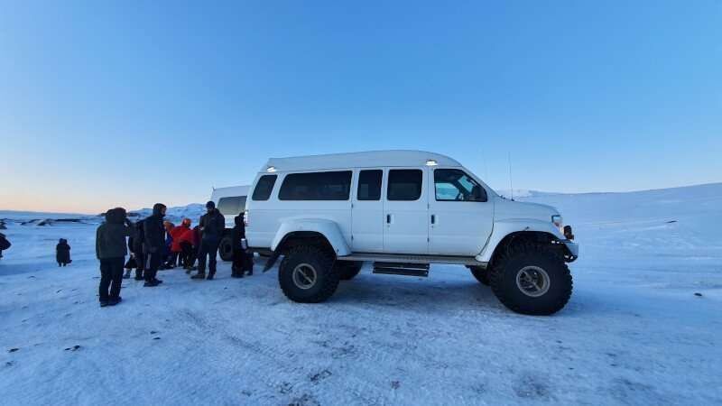 Ice Cave 4WD, car on snowy plains with people preparing for the tour