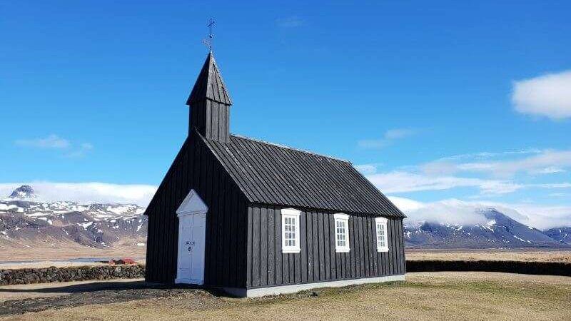 Budakirkja - Black Church with snowy mountains on a sunny day