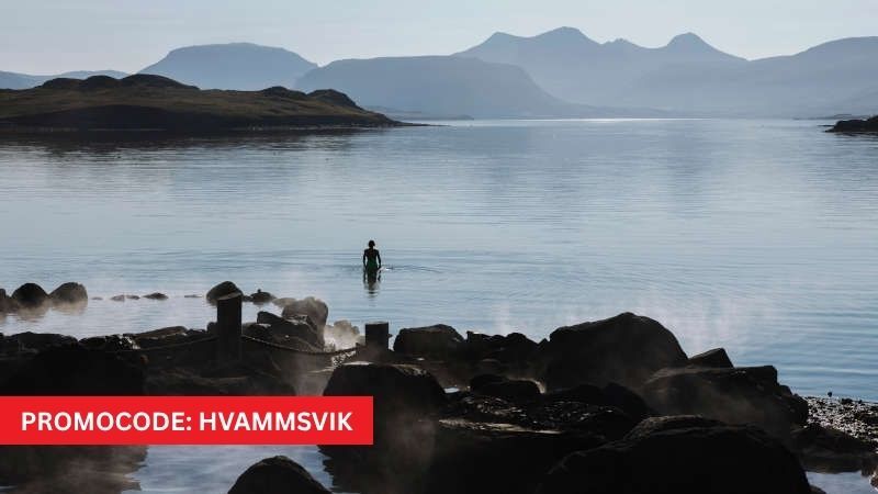 Hvammsvik spa in Iceland with woman swimming in the ocean