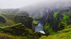 Fjaðrárgljúfur River Canyon on a cloudy day, green gorge with a river