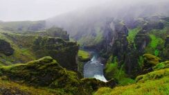 Fjaðrárgljúfur River Canyon on a cloudy day, green gorge with a river